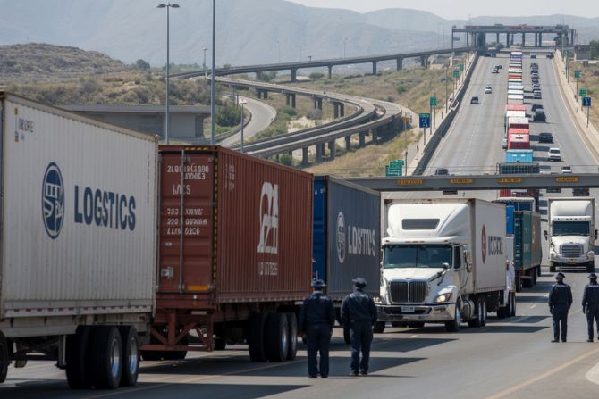 Long lines of trucks at a U.S.-Mexico border checkpoint showing congestion and capacity constraints in cross-border shipping.
