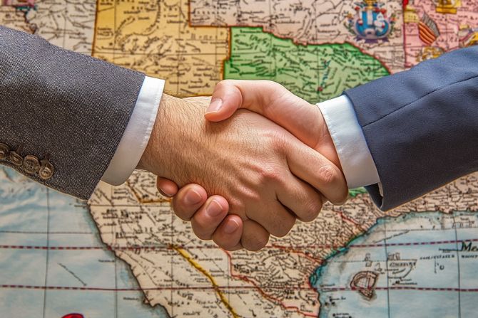business handshake in front of a map, symbolizing cross-border logistics or international business partnership.