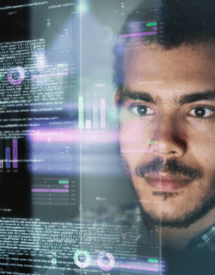 man looking at a screen software code and charts
