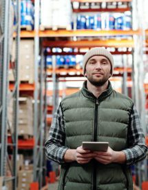 A man with a notepad standing in a warehouse